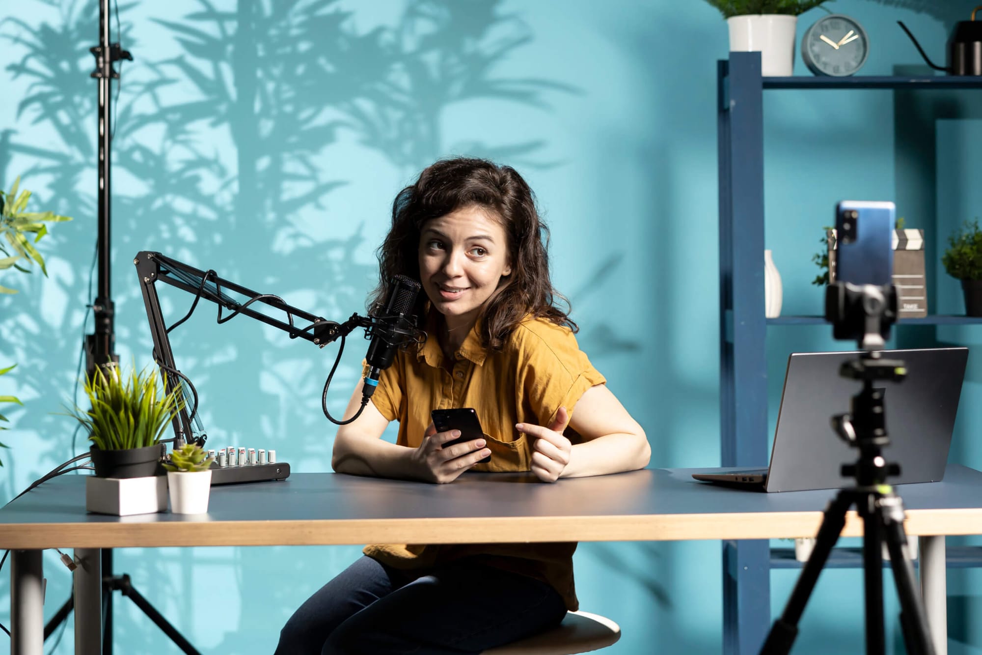 Woman recording a podcast with a mic and phone