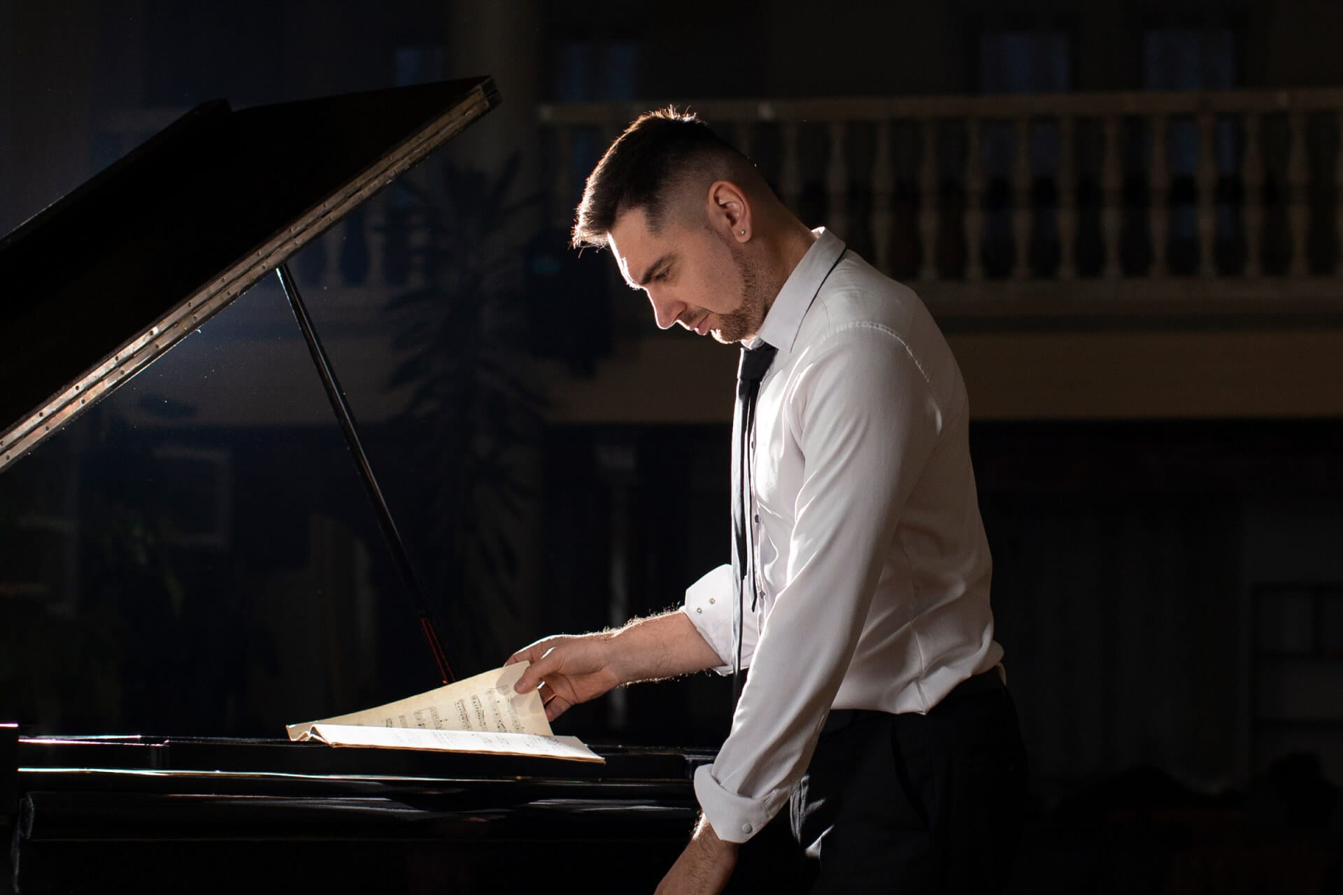 A pianist reading sheet music at a grand piano