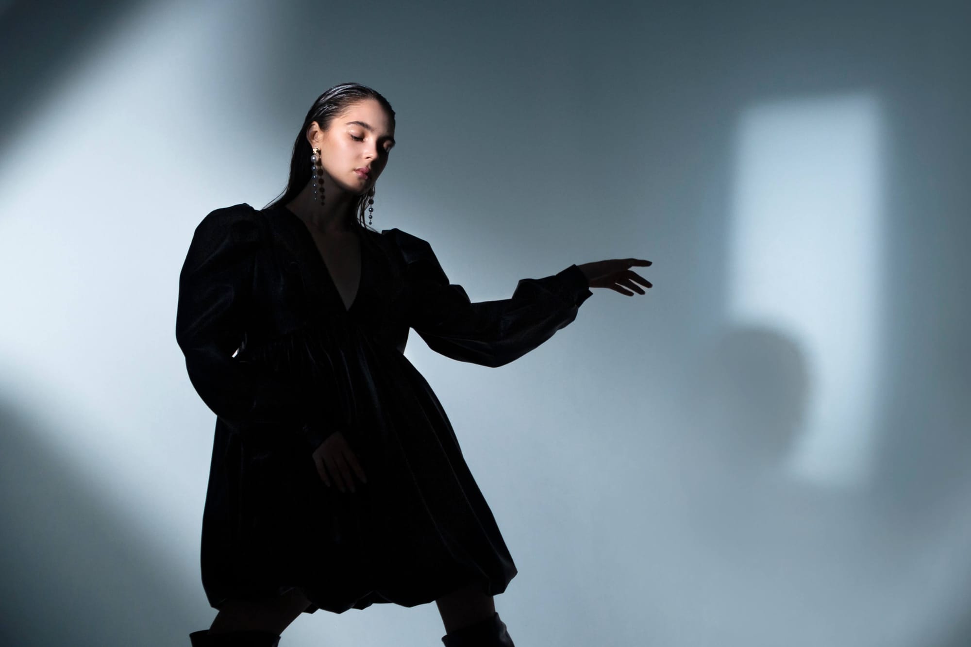 Moody portrait of a woman in a black dress with dramatic lighting