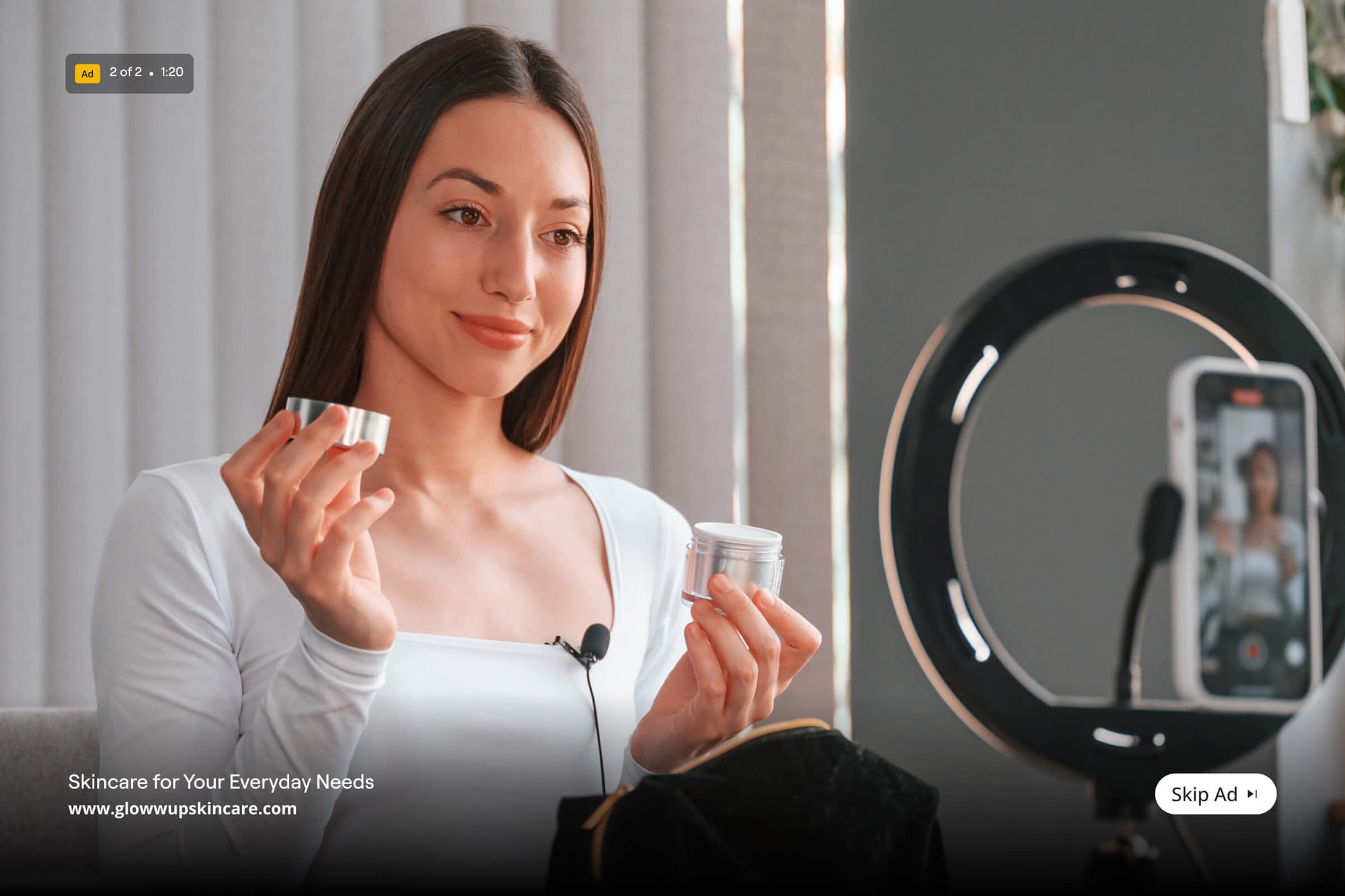 Woman filming a skincare product review with a phone and ring light.